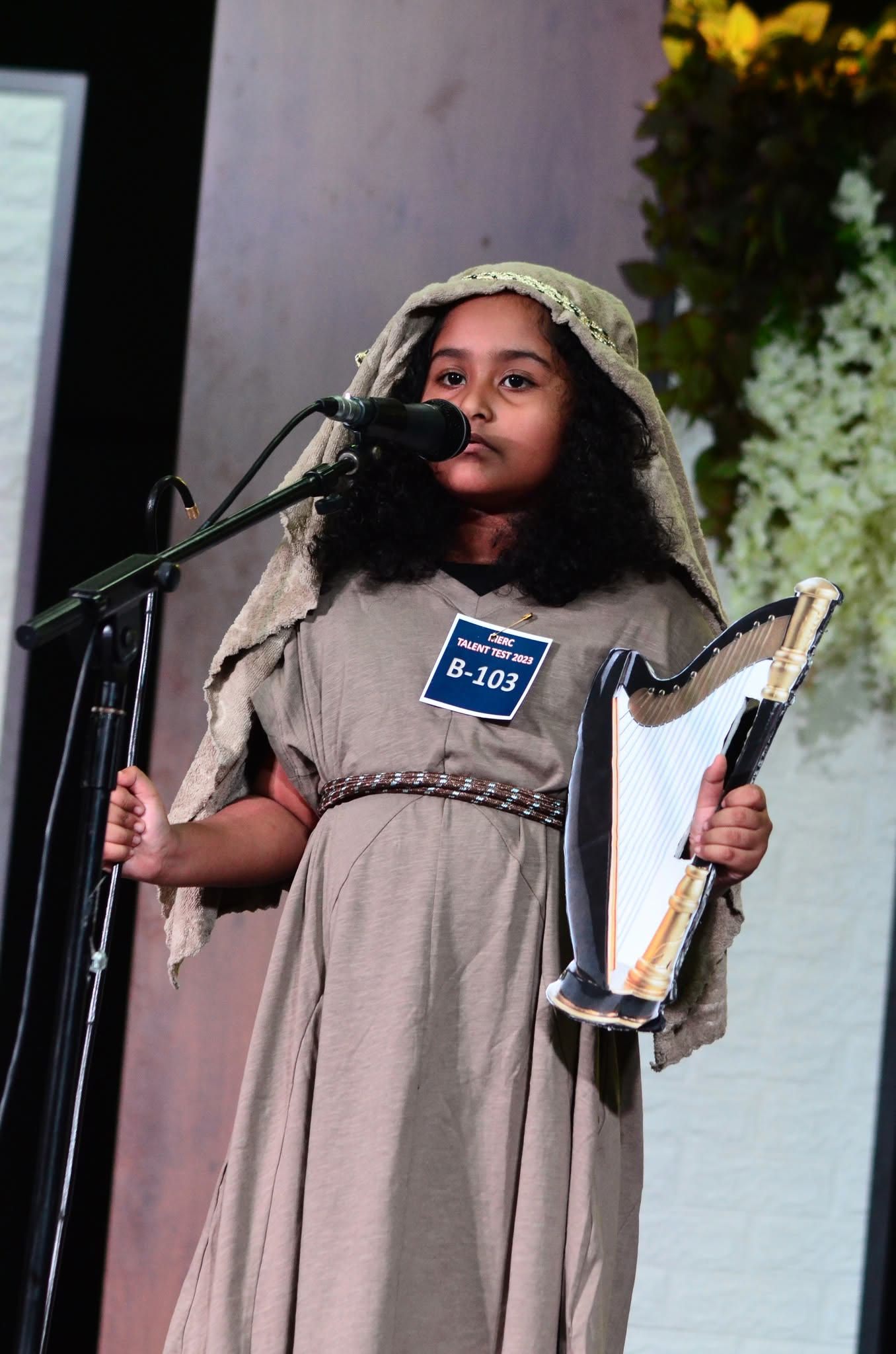 Child dressed as David with a harp at the talent test